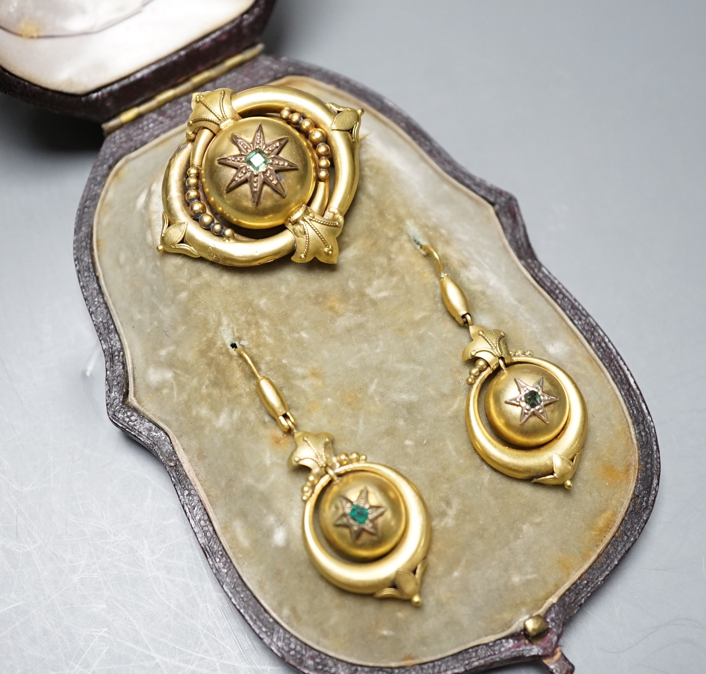 A cased Victorian yellow metal and emerald? set demi parure, comprising a brooch and pair of drop earrings, brooch width 41mm, gross weight 10.8 grams.